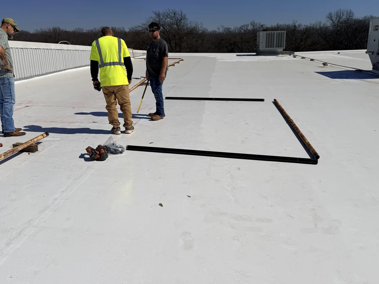 Ramtech crew laying out a repair area on a white single-ply TPO roof