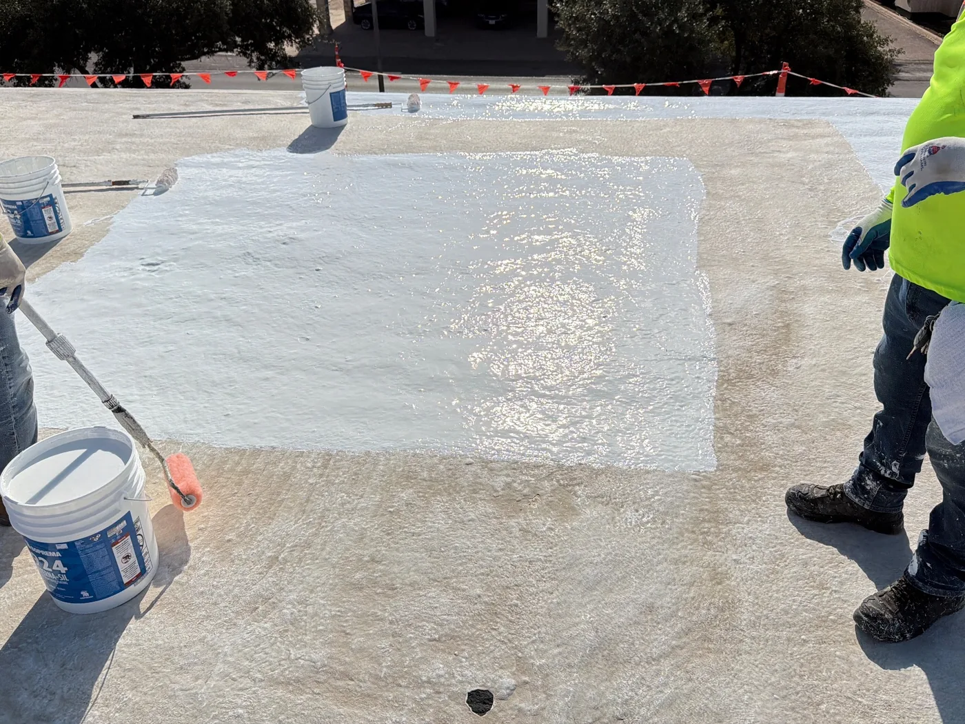 Crew rolling a white section onto a commercial roof in Ballinger, Texas