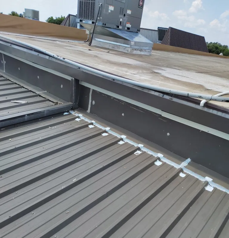 Closures sealed where a metal roof meets the wall