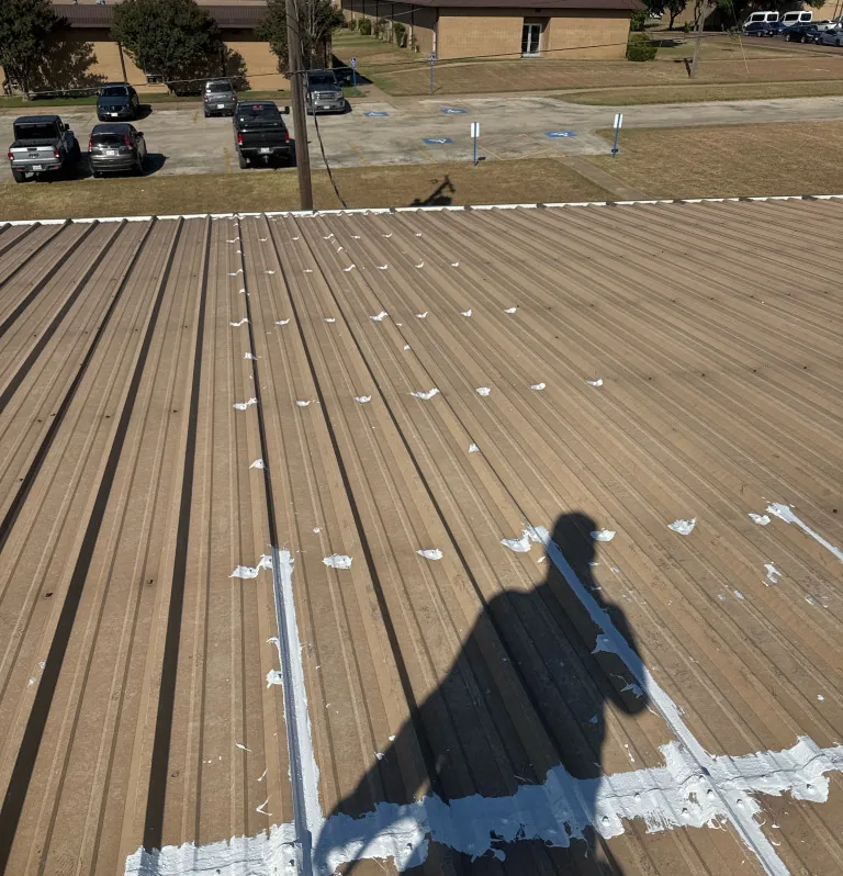 Rows of sealed seam repairs on a brown metal roof