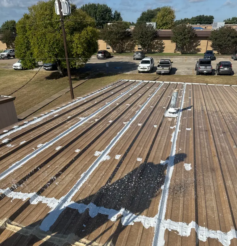 Sealed seams and fasteners across a standing seam metal roof on a community college building in Central Texas
