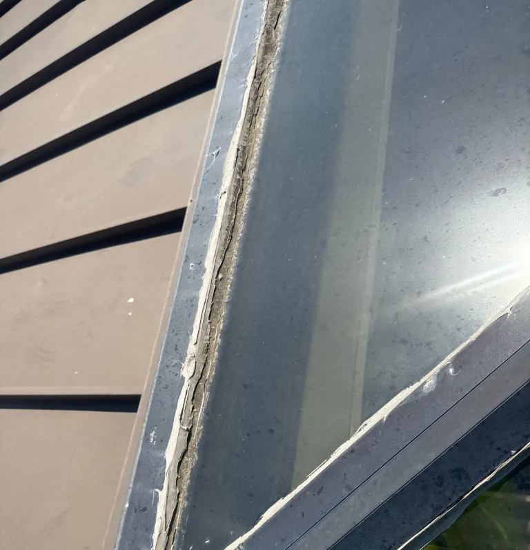 Resealed sheet metal base at a skylight
