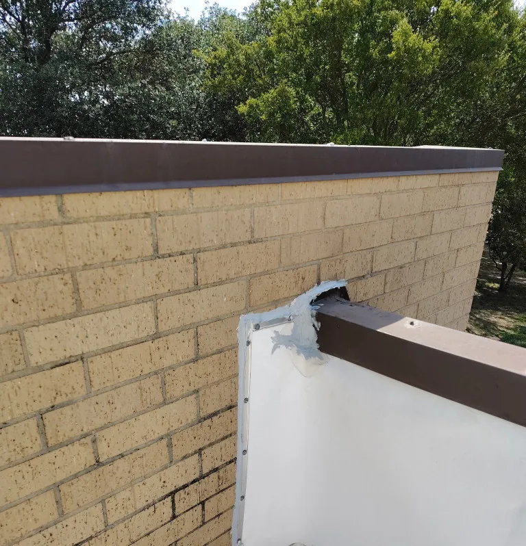 Termination bar sealed where a single-ply roof meets a brick wall