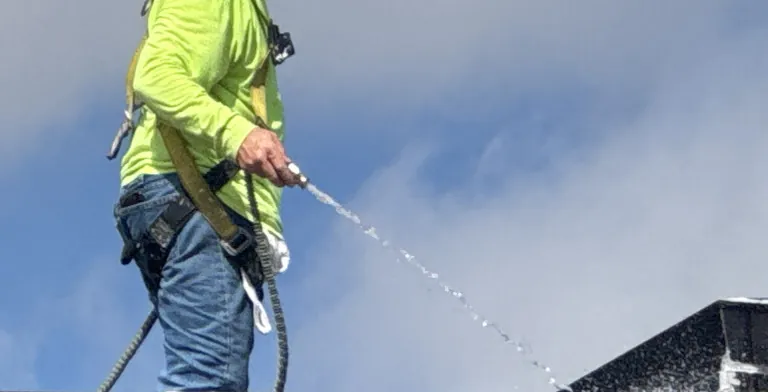 Ramtech crew water-testing repaired leak points on a college roof
