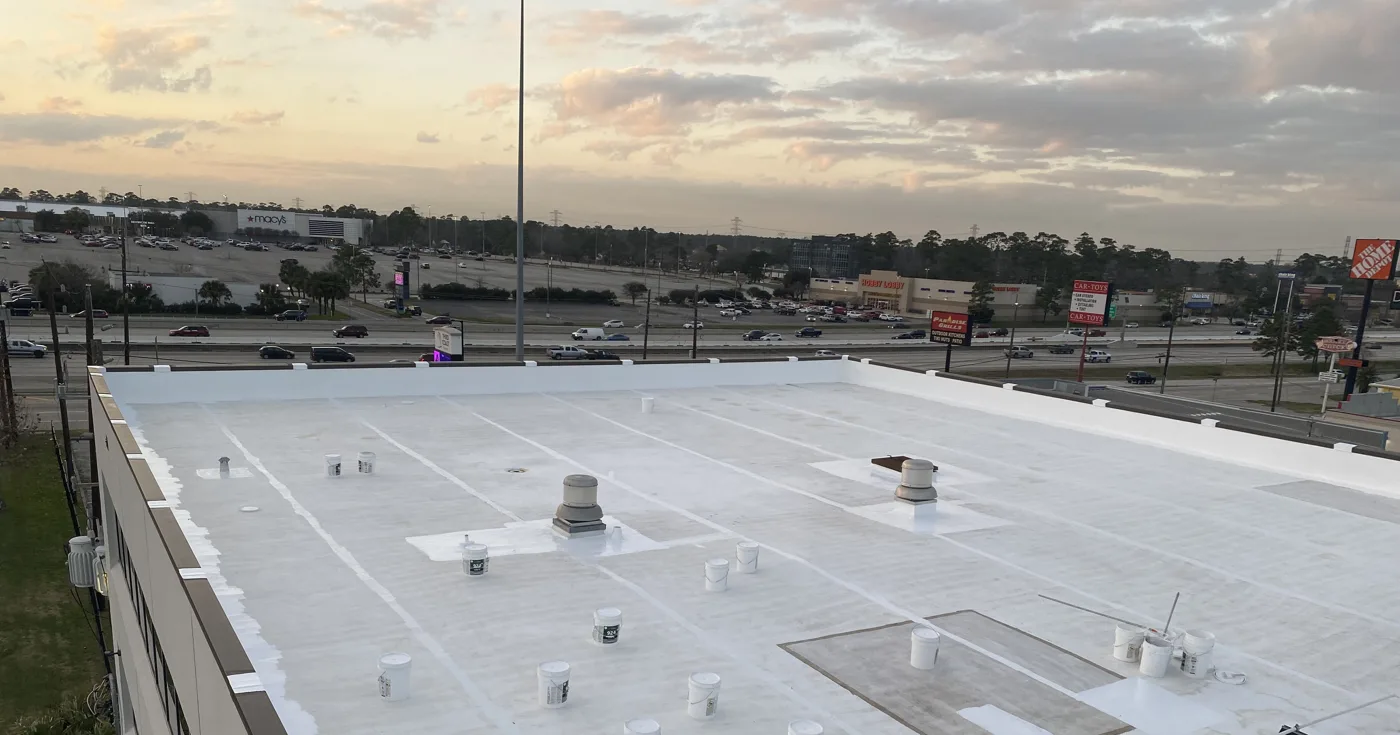 Finished white silicone roof with vents on a low-slope commercial building