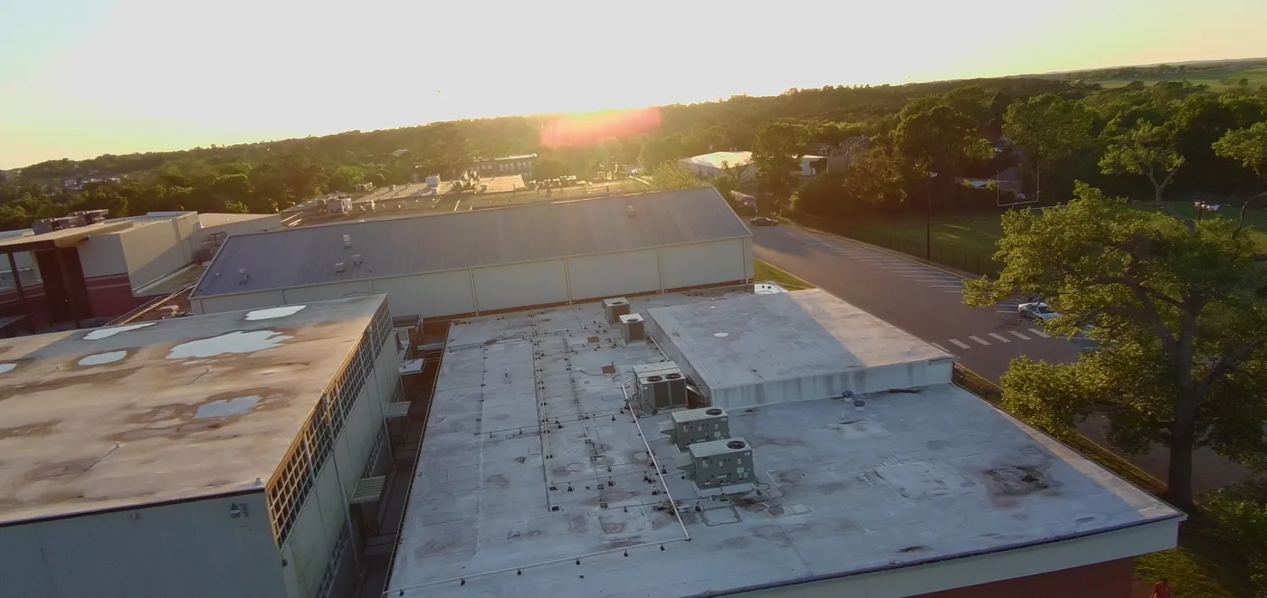 Sunset drone view of the school band hall roof before restoration