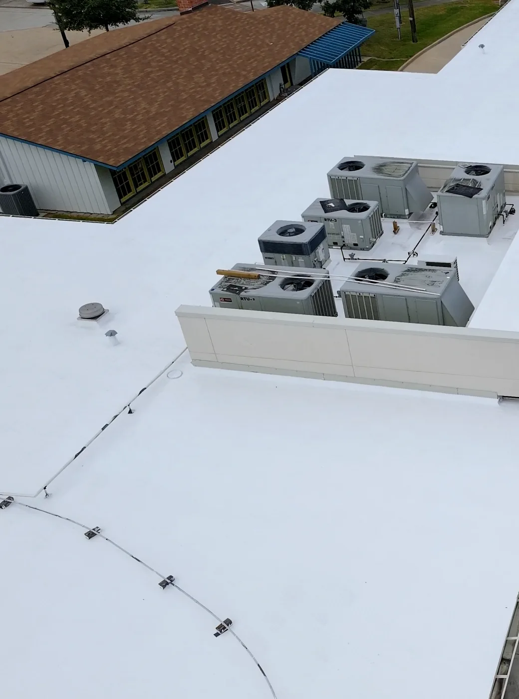 Finished white silicone roof around rooftop HVAC units on a bank building