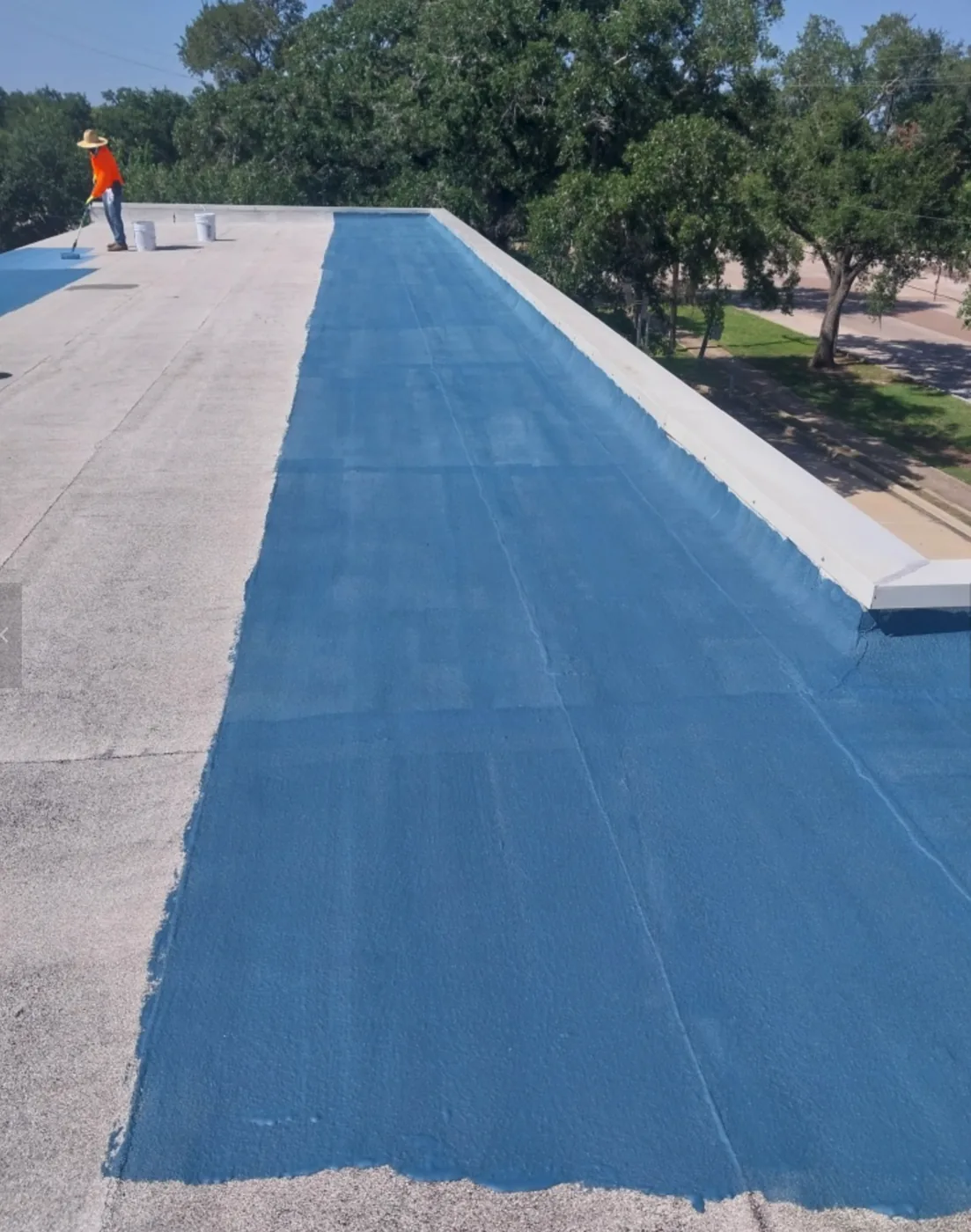 Blue base layer applied along a roof edge, half complete