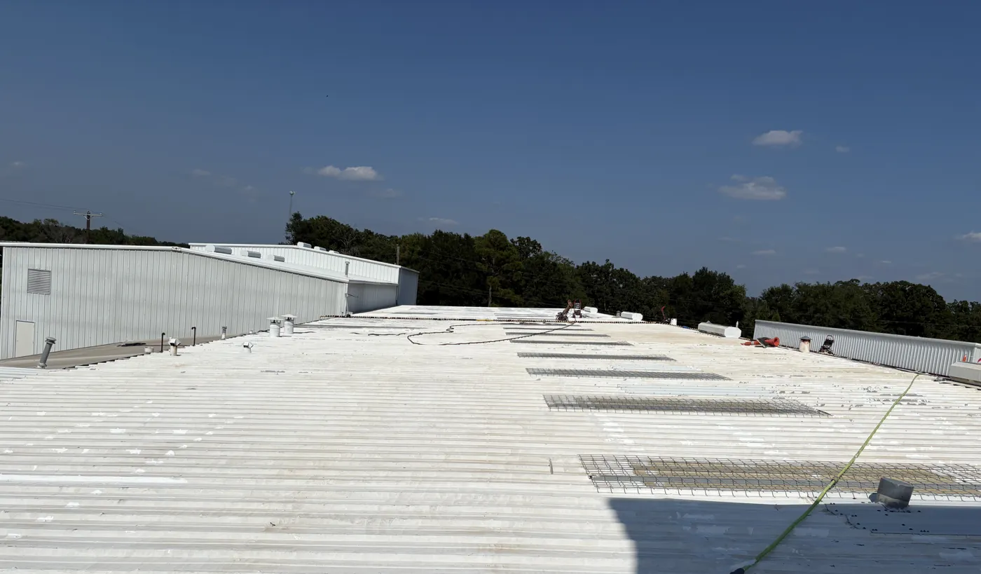 Metal roof restoration in progress at an industrial plant in Malakoff, Texas