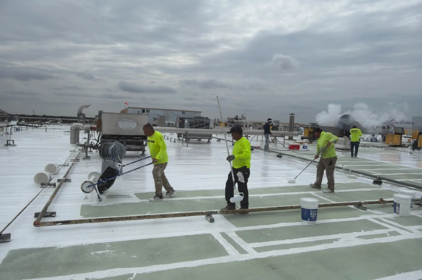 Ramtech crew spreading the fluid-applied restoration across the roof field