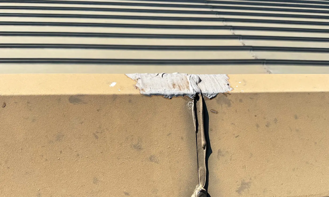 Failed sealant running down a metal flashing seam