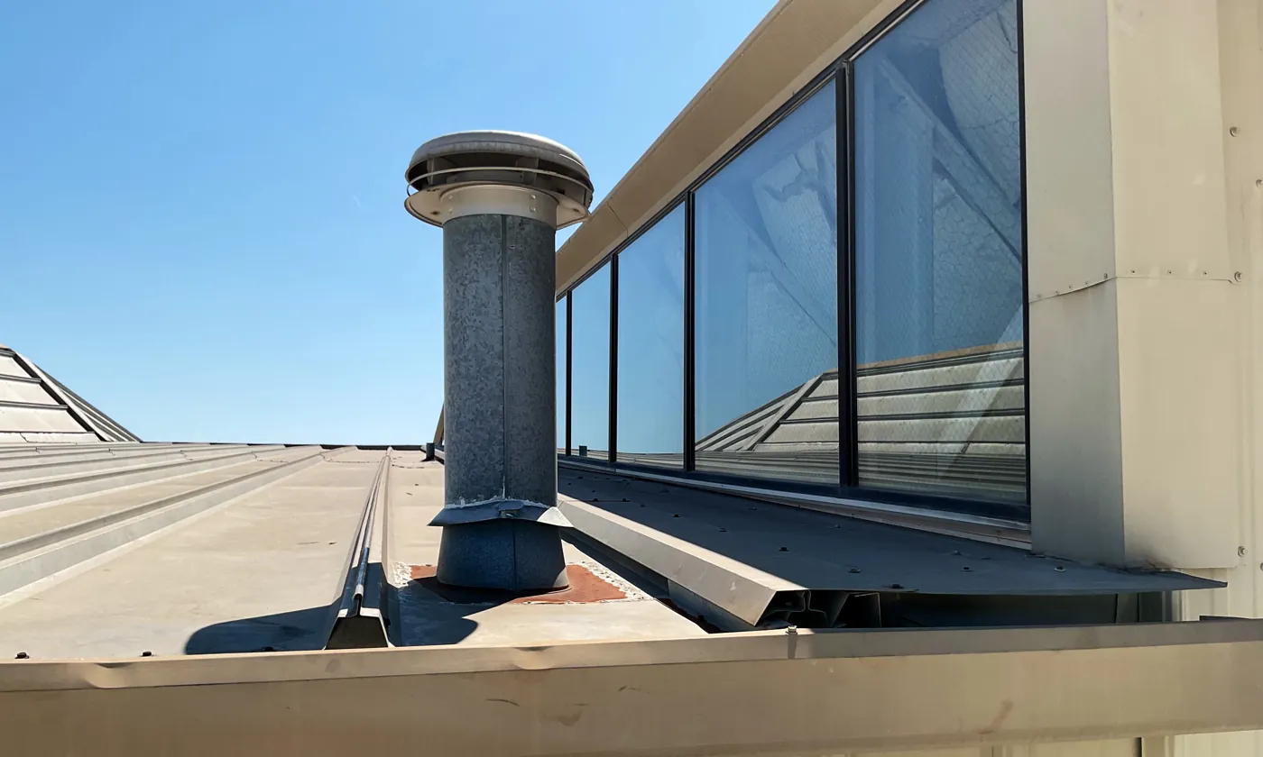 Skylight curb and vent on a metal roof at a technical college diesel technology building in Waco