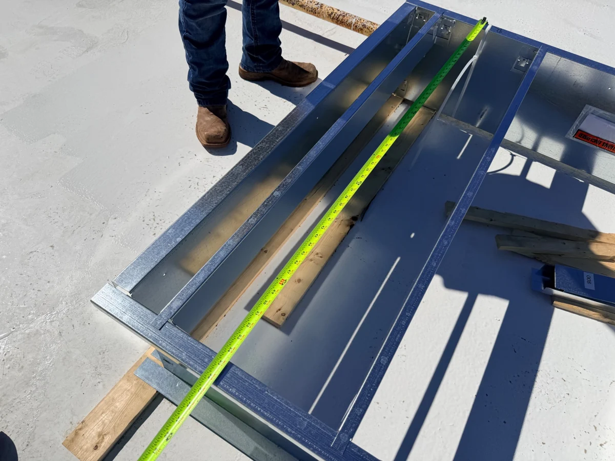 A tape measure laid along metalwork on a commercial roof